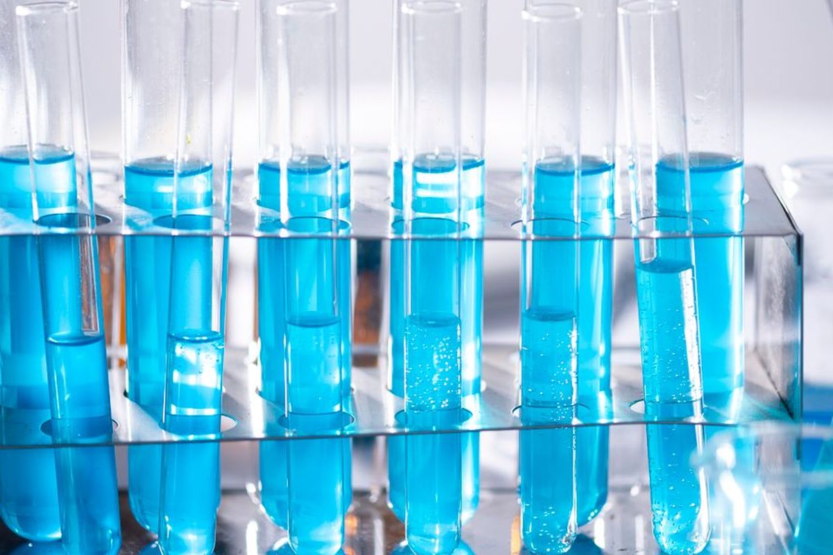 Laboratory test tubes with blue samples in a metal rack