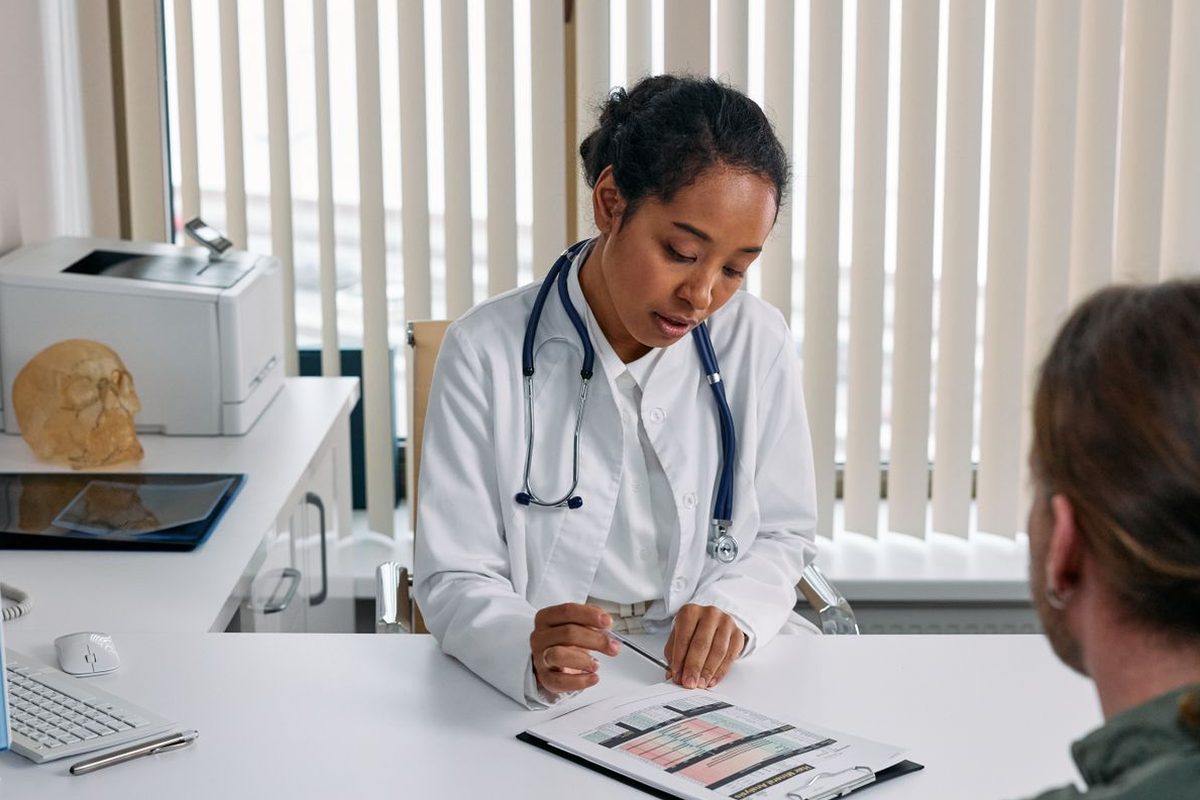 Clinician reviewing a chart with a patient in a bright exam office